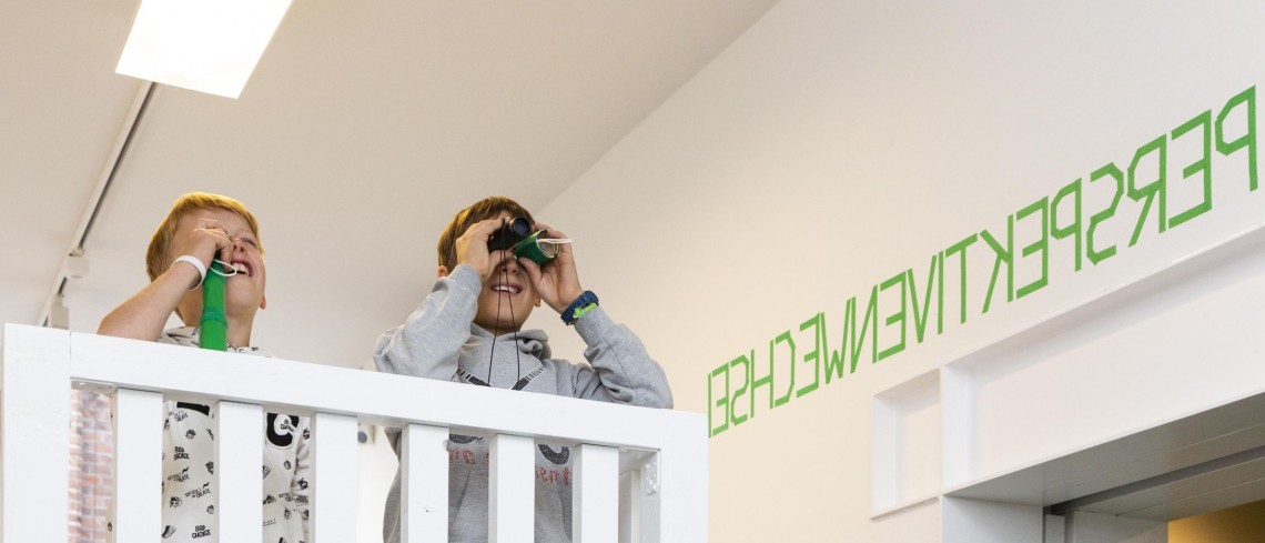 Zwei Kinder stehen auf einer Empore und schauen mit Ferngl&auml;ser in den Ausstellungsraum.