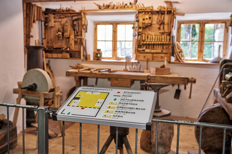 Ein tastbarer Grundriss ist auf der Abtrennung zu einer einer historischen Werkstatt installiert.