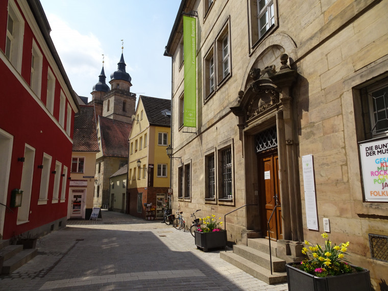 An einer Stra&szlig;e liegt der Eingang zum Museum, das mit einem barocken Portal aus Stein zum Betreten einl&auml;dt.