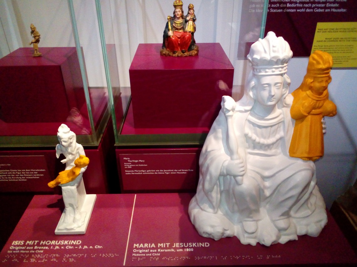 Eine Marienfigur unter einer Glashaube. Davor steht das Tastmodell passend zum Objekt.