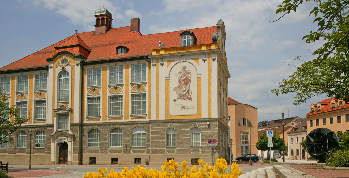 Ein gro&szlig;es historisches Geb&auml;ude mit drei Stockwerken und gro&szlig;en Fenstern. 