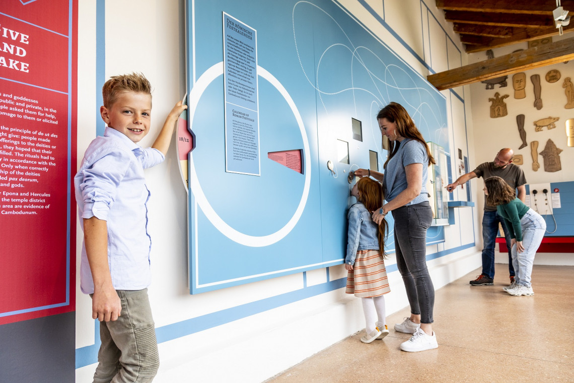 Eine Familie mit drei Kindern probiert die Mitmachstationen aus, darunter eine Riechstation.